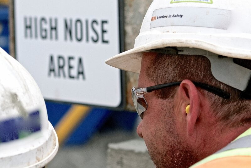 Man using foam ear defenders in a high noise construction area